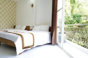 ein Schlafzimmer mit einem Bett neben einem Fenster in der Unterkunft HongKong1 Hotel Quy Nhon in Quy Nhon