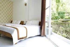 a bedroom with a bed next to a window at HongKong1 Hotel Quy Nhon in Quy Nhon