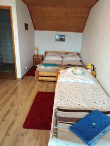 Habitación con 2 camas individuales y suelo de madera. en U Halinki, en Uherce Mineralne