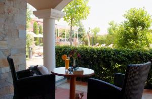 eine Terrasse mit einem Tisch, Stühlen und einem Zaun in der Unterkunft Helena VIP Villas and Suites - Half Board in Sonnenstrand
