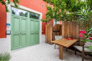 d'une terrasse avec une porte verte et une table en bois. dans l'établissement Lyon Urban Cocoon Gîte urbain eco-responsable, à Lyon