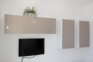 a flat screen tv on a white wall at Villa Azzurra a pochi passi dal mare in San Vito lo Capo