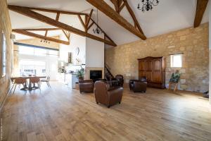 una gran sala de estar con suelo de madera y mesa. en Domaine du chauvet en Sainte-Eulalie