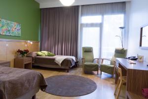 Habitación de hotel con cama, mesa y sillas en Hotelli Kunnonlähde Kankaanpää, en Kankaanpää