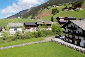 ein Dorf in den Bergen mit Häusern und Gras in der Unterkunft Gästehaus Lienharterhof in Obertilliach