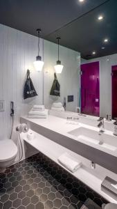 a bathroom with a sink and a toilet and a mirror at Original Sokos Hotel Kupittaa in Turku