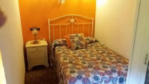 ein Schlafzimmer mit einem Bett und einer Lampe auf einem Nachttisch in der Unterkunft La Casina de Abo in El Manto