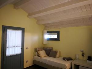 1 dormitorio con cama, ventana y puerta en Alloggio Al San Girolamo, en Longiano