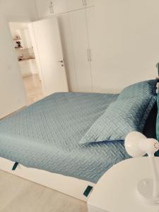 um quarto com uma cama com um cobertor azul em Saranda Terrace Apt. Rooms em Saranda