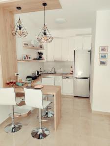 uma cozinha com uma mesa de madeira e um frigorífico em Saranda Terrace Apt. Rooms em Saranda