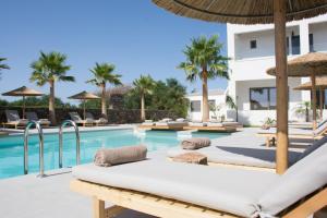 a pool with chairs and umbrellas next to a building at Aqua Blu "Adults Only" - "by Checkin" in Hersonissos