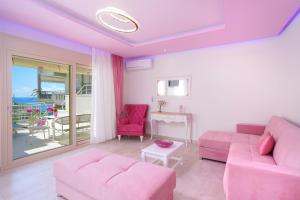 a living room with pink furniture and a balcony at Dream View in Skala Marion