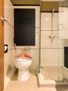 a bathroom with a toilet and a glass shower at Hotel M Chiang Mai in Chiang Mai