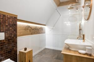 une salle de bain blanche avec un lavabo et un miroir dans l'établissement Villa Hello Tatry, à Zakopane
