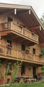 una casa de madera con balcones y flores. en Green Hills Appaloosa Ranch, en Waakirchen