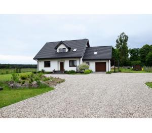 a house with a gravel driveway in front of it at Pod Wielkim Wozem in Jerutki