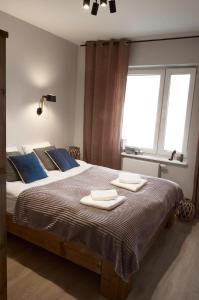 een slaapkamer met een groot bed en handdoeken bij Między Nami Apartamenty in Szczyrk