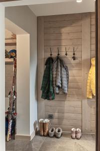 een kamer met een houten muur met jassen en schoenen bij Między Nami Apartamenty in Szczyrk