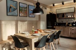 a dining room with a wooden table and chairs at Między Nami Apartamenty in Szczyrk