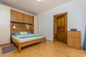 a bedroom with a bed with a wooden headboard at Guesthouse Casa Nova in Poreč