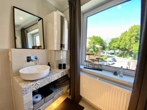a bathroom with a sink and a large window at Schöne Ferienwohnungen teilweise mit Dachterrasse im Herzen von Itzehoe in Itzehoe +89 photos