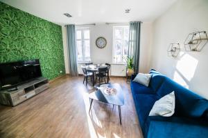 uma sala de estar com um sofá azul e uma mesa em 4YOU APARTMENT em Toruń