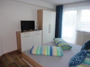 a bedroom with a bed with two pillows and a tv at Apart Kofler in Längenfeld