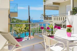 a balcony with tables and chairs and a view of the ocean at Dream View in Skala Marion