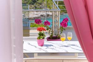 einen Tisch mit zwei Gläsern Wein und Blumen auf dem Balkon in der Unterkunft Dream View in Skala Marion