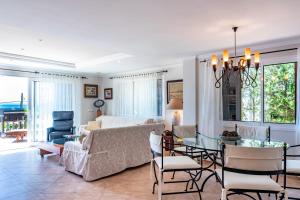 a living room and dining room with a couch and a table at Villa FARO Alcanada - Alcudia in Alcudia