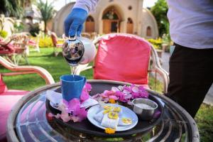 una persona vertiendo vino en una copa sobre una mesa en Embrace Hotel en Luxor