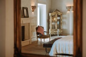 a bedroom with a bed and a chair and a mirror at Paragon 700 Boutique Hotel & SPA in Ostuni