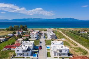 an aerial view of a town with houses and the ocean at Thalassa & Thalassa Prive Residential Complex in Ofrínion