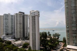 un edificio blanco alto junto a un cuerpo de agua en Profolio @ Mansion One, en George Town