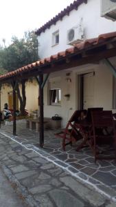 a patio with a wooden pergola next to a house at Anemos Studios in Vassilias