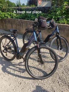 una bicicleta estacionada en un camino de grava junto a una pared en L'intervalle des 18 châteaux, en Saint-Georges-sur-Cher