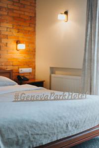 a bedroom with a bed and a brick wall at Geneva Park Hotel in Odesa