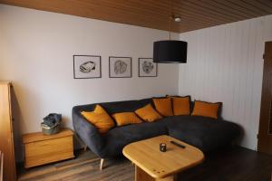 Ferienhaus Irene في فريدريشسهافن: غرفة معيشة مع أريكة سوداء وطاولة