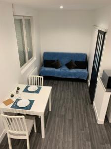 a living room with a blue couch and a table at AZUR in Saint-Nazaire