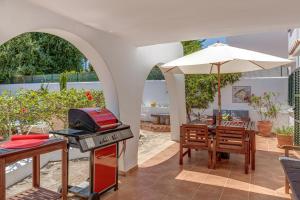 a kitchen with a grill and a table with an umbrella at Sweet Family House in Cala d´Or