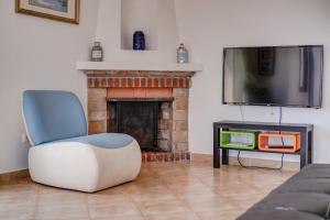 a living room with a chair and a fireplace at Sweet Family House in Cala d´Or