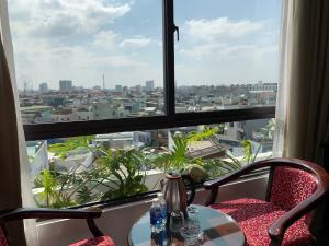 una mesa y una silla frente a una gran ventana en Khanh Linh Hotel en Da Nang