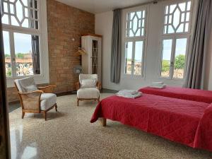 um quarto com 2 camas, 2 cadeiras e janelas em Ca Favorita em Veneza-Lido