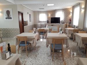 a dining room with tables and chairs and a tv at Hostal Moreno in Silla