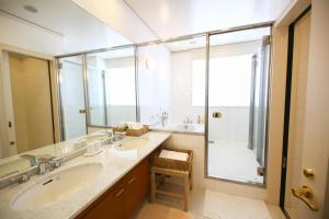 a bathroom with two sinks and a shower at Hotel Marital Sousei Kurume in Kurume