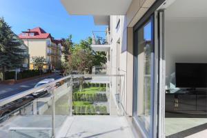 - Balcón de cristal con vistas a la calle en Apartament Szafirowy, en Świnoujście