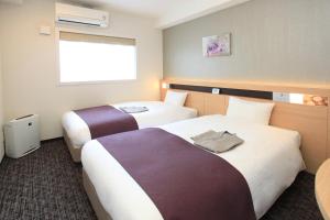 a hotel room with two beds and two lamps at Urban Hotel Kyoto Nijo Premium in Kyoto