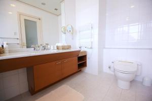 a white bathroom with a toilet and a sink at Hotel Marital Sousei Kurume in Kurume