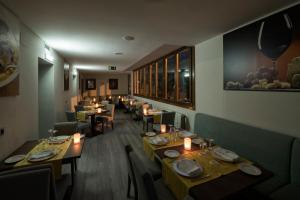 a dining room with tables and chairs and candles at Hotel Rural Las Montañas de Pumar in Besullo