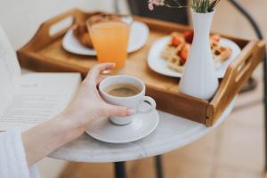 a person holding a cup of coffee on a table at Geneva Park Hotel in Odesa